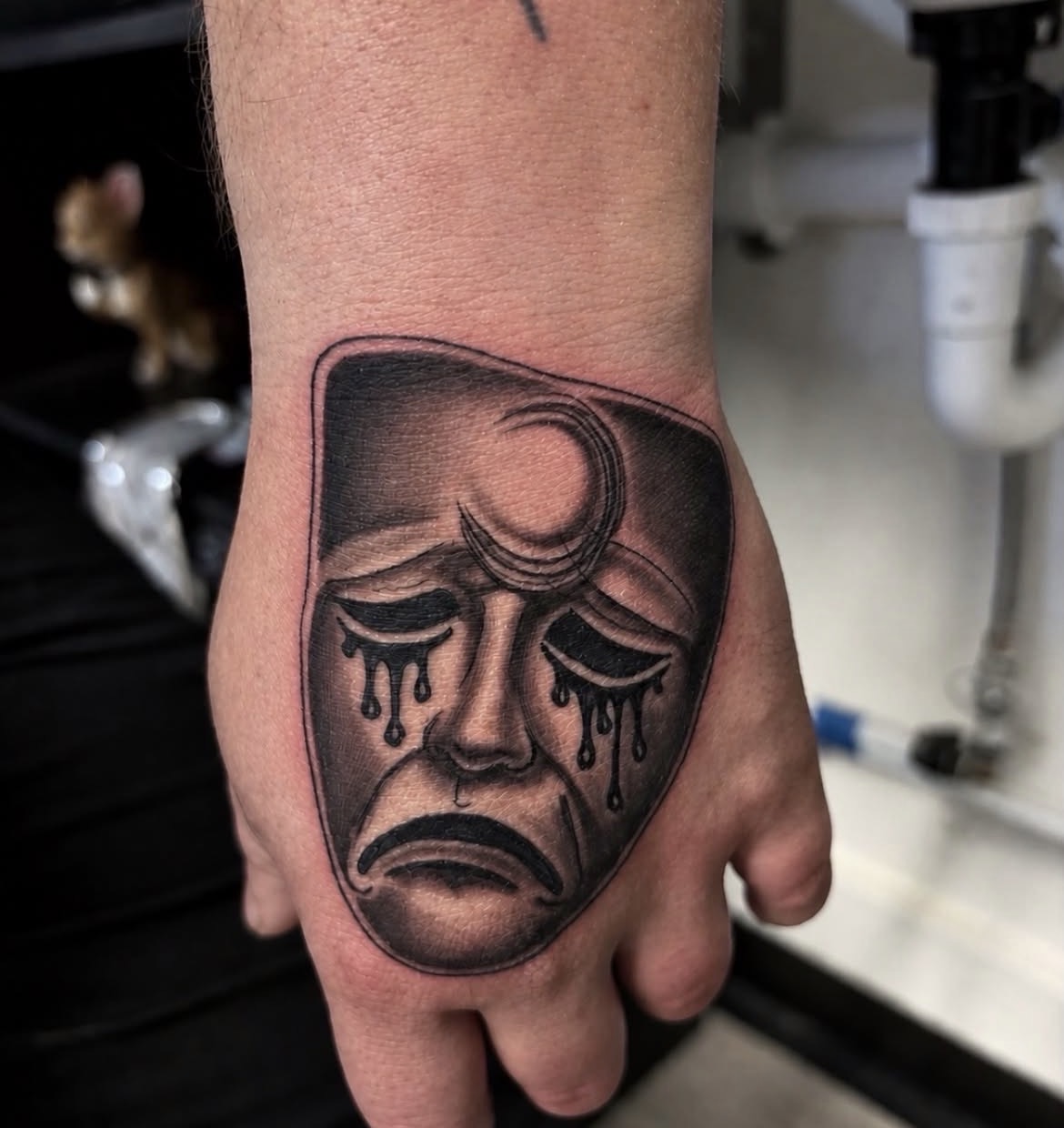 Theatrical mask tattoo by Jake Bebout at Snafu Tattoo Studio in Wilmington NC